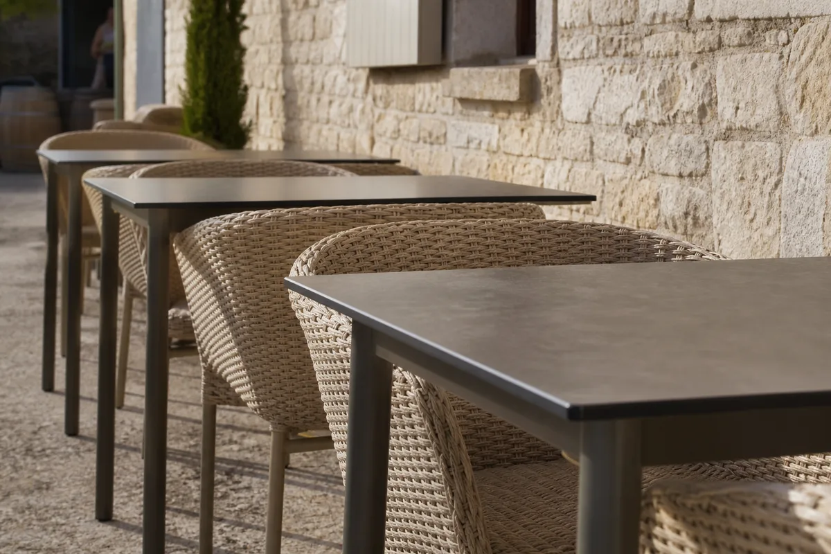 Mobilier de terrasse professionnel en aluminium et résine tressée aligné sur une terrasse de domaine viticole